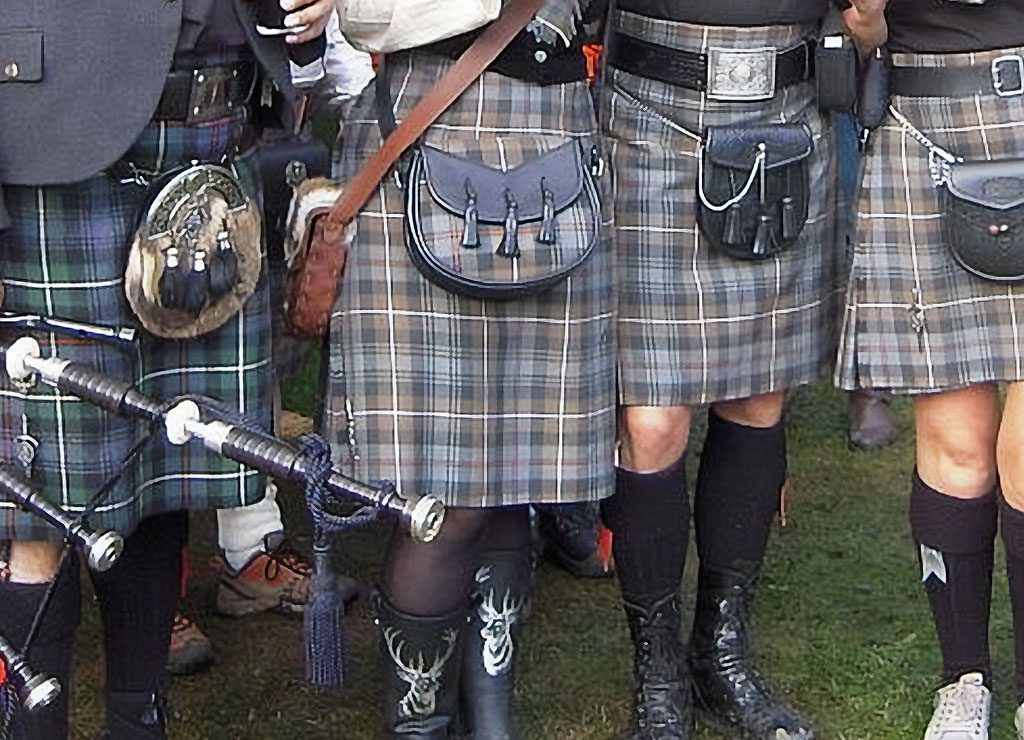 Gruppe in karierten Kilts mit traditionellen Sporrans, zu sehen sind nur die Beine.