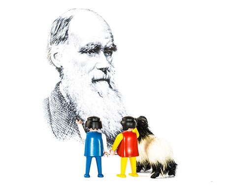 Zwei Playmobil-Figuren und ein Tier sehen ein Porträt von Charles Darwin an.