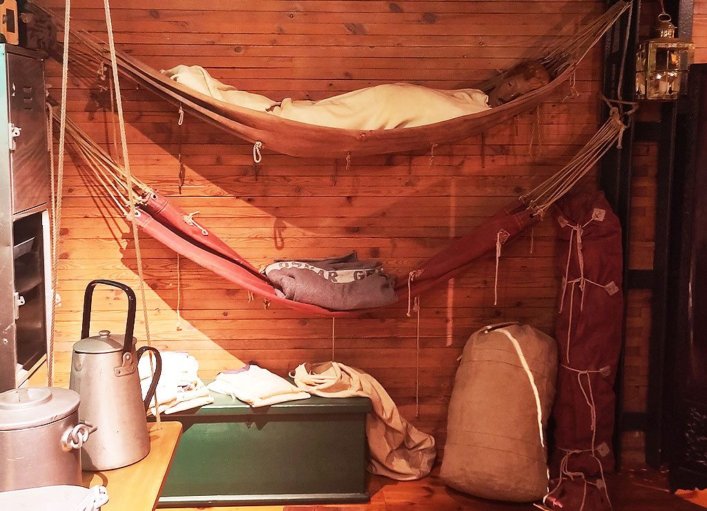 Hammock Day – Tag der Hängematte in den USA. Kuriose Feiertage - 22. Juli © 2024 Sven Giese - Bild 1 Zwei übereinander gespannte Hängematten in einer Kajüte mit Holzverkleidung und Requisiten.
