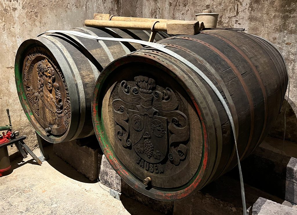 National Wine Day – Tag des Weins in den USA. Kuriose Feiertage – 25. Mai © 2026 Sven Giese - Bild 2 Zwei große Weinfässer stehen im Keller, verziert mit geschnitzten Wappen und Metallreifen.
