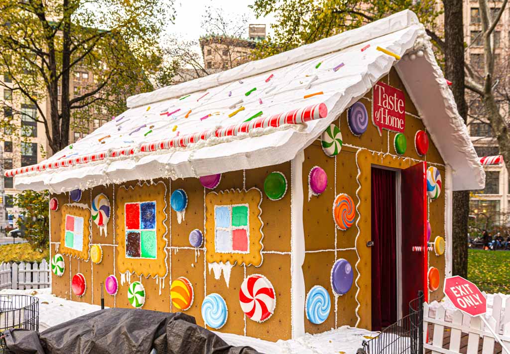 Lebensgroßer Nachbau eines Lebkuchenhauses mit bunten Zuckerdekorationen und Schriftzug „Taste of Home“ im Freien.