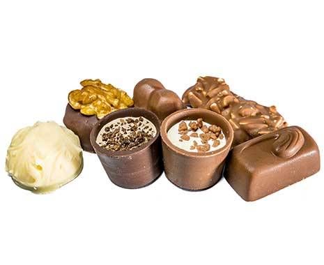 Verschiedene Pralinen mit Nüssen, Schokolade und weißer Glasur auf weißem Hintergrund.