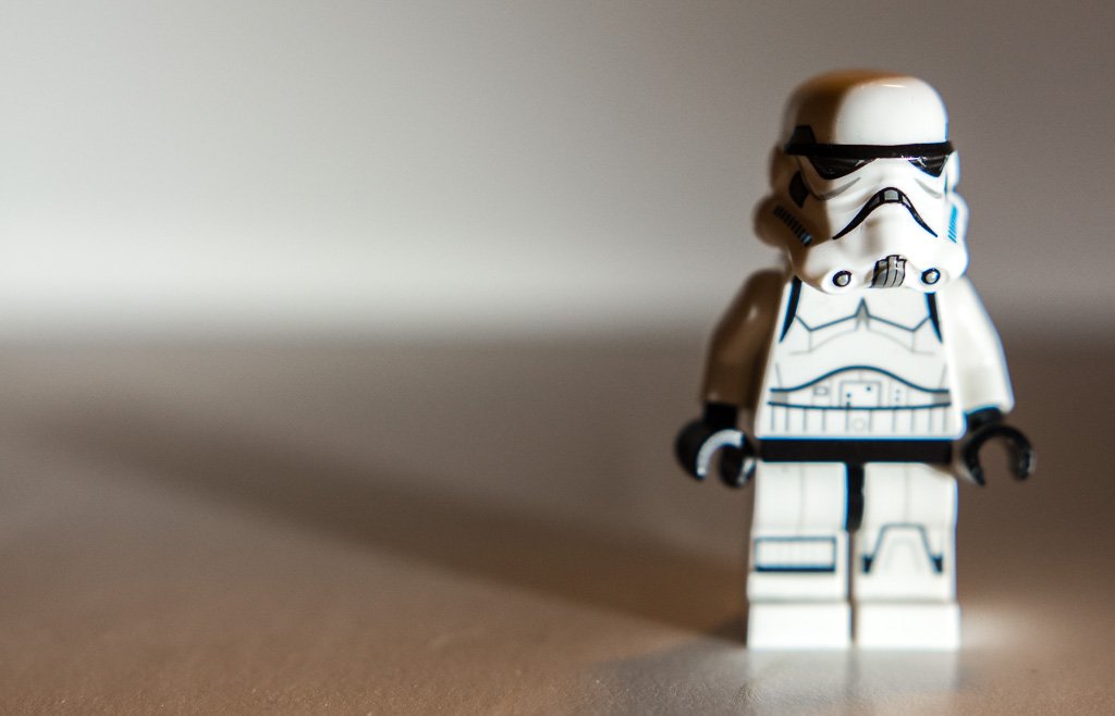 LEGO Stormtrooper-Figur im Nahbereich auf beigem Untergrund, mit langer Schattenwirkung.