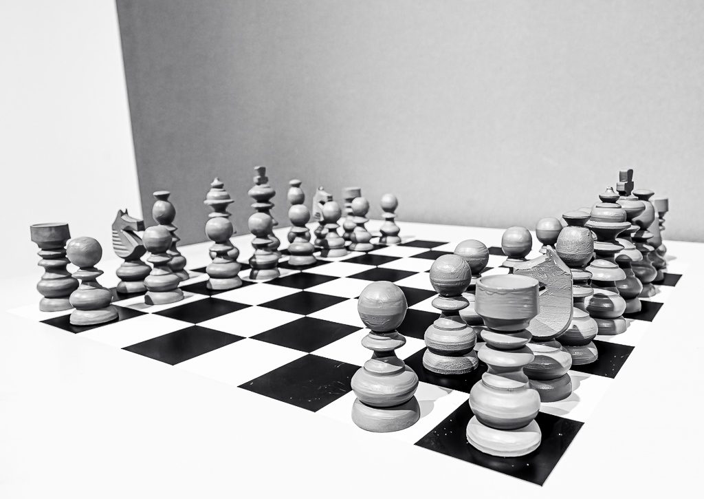 Komplettes Schachbrett mit einzigartig geformten Spielfiguren in symmetrischer Anordnung.