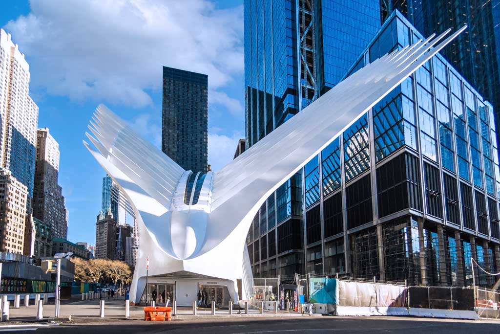World Day of Architecture – Internationaler Tag der Architektur. Kuriose Feiertage – erster Montag im Oktober © 2023 Sven Giese – Bild 1 The Oculus in New York. Ein futuristisches weißes Gebäude mit Flügeln, umgeben von Hochhäusern in einer Großstadt bei klarem Himmel.