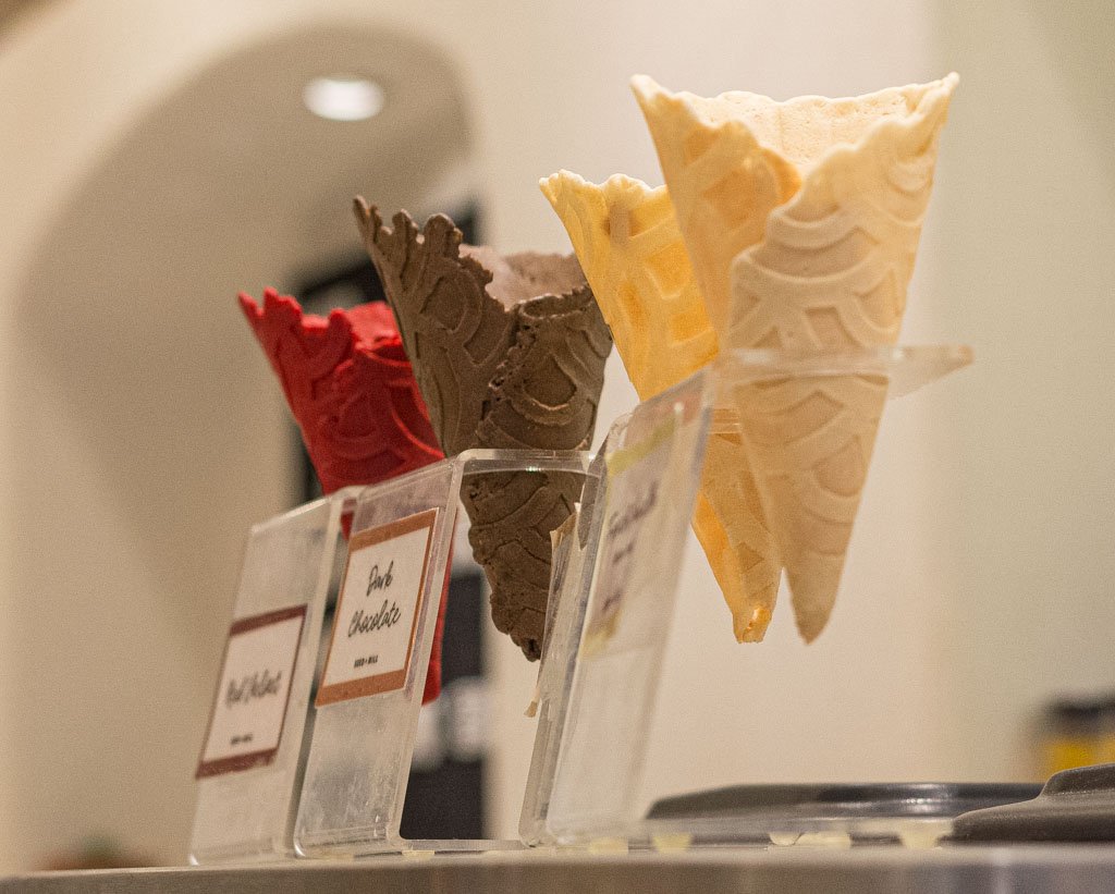 National Ice Cream Cone Day – Tag der Eistüte in den USA. Kuriose Feiertage - 22. September © 2018 Sven Giese – Bild 3 Mehrere Eiswaffeln in unterschiedlichen Farben stehen in einer Eisdiele zur Auswahl.