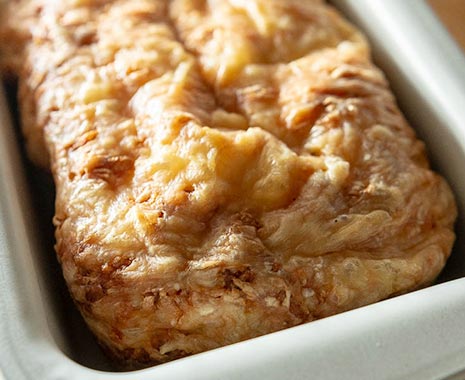 Hausgebackenes Brot mit Käse und Schinken in einer Brotbackform. Tag des selbstgebackenen Brotes - Homemade Bread Day in den USA. Kuriose Feiertage - 17. November © 2019 Sven Giese