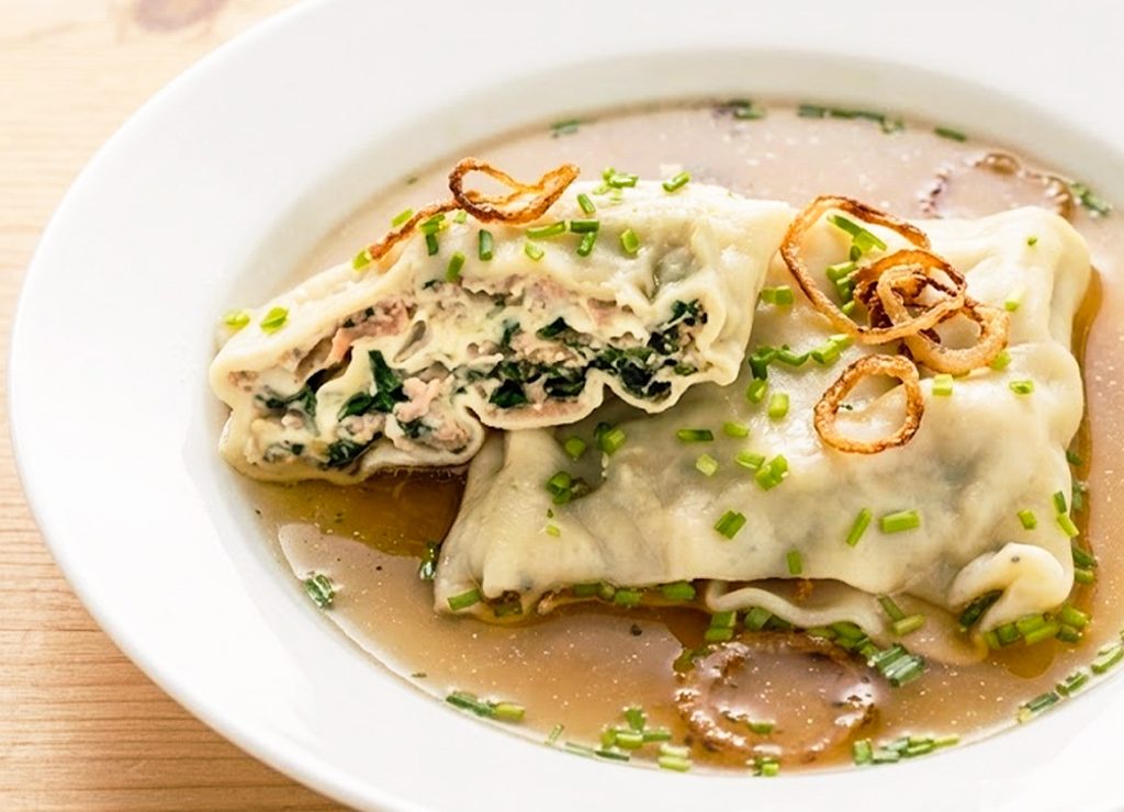 Weltmaultaschentag. Kuriose Feiertage – Gründonnerstag © 2026 Sven Giese - Bild 1 Teller mit Maultaschen in klarer Brühe, garniert mit Schnittlauch und Röstzwiebelringen.