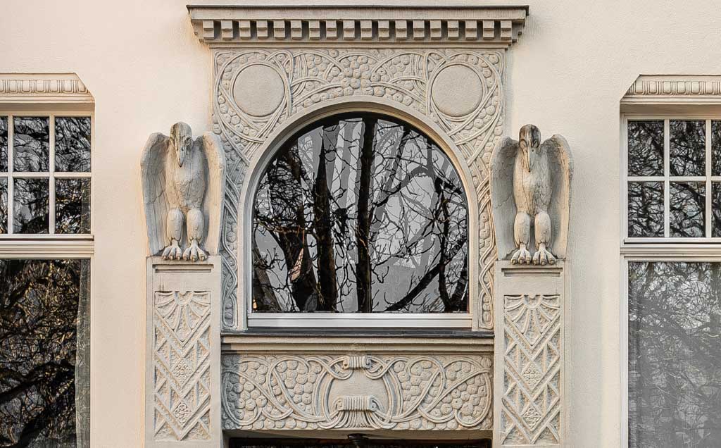 World Art Nouveau Day – Weltjugendstiltag. Kuriose Feiertage - 10. Juni © 2024 Sven Giese – Bild 2 Aufwendig, im Jugendstil verziertes Portal mit Rundbogenfenster und zwei steinernen Greifen.