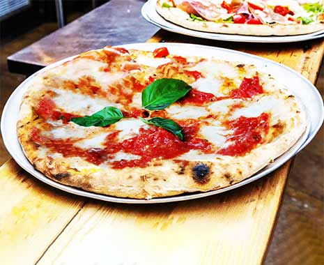 Frisch gebackene Pizza Margherita mit Tomatensauce, Mozzarella und Basilikum.