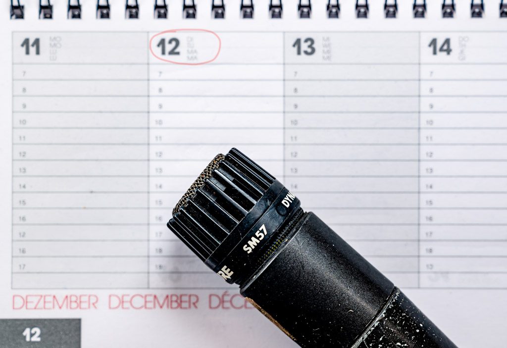 Nahaufnahme eines Mikrofons auf einem Kalender, der 12. Dezember ist rot eingekreist.