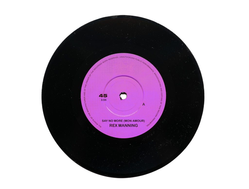 Schwarze Vinyl-Single mit pinkem Label, Aufdruck: "Say No More" von Rex Manning.
