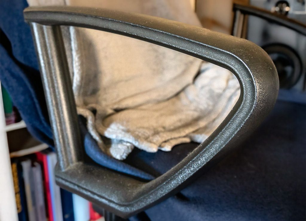 Tag der Armlehne in Deutschland. Kuriose Feiertage - 17. Mai © 2025 Sven Giese Nahaufnahme einer Armlehne an einem Bürostuhl mit einer weichen Decke auf dem Sitz.