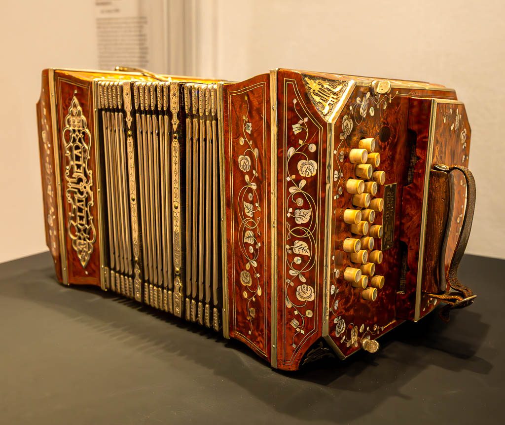 Día del Bandoneón – Tag des Bandoneons in Argentinien. Kuriose Feiertage 11. Juli © 2025 Sven Giese – Bild 1 Detailreich verziertes Bandoneon mit floralen Intarsien und goldenen Tasten.