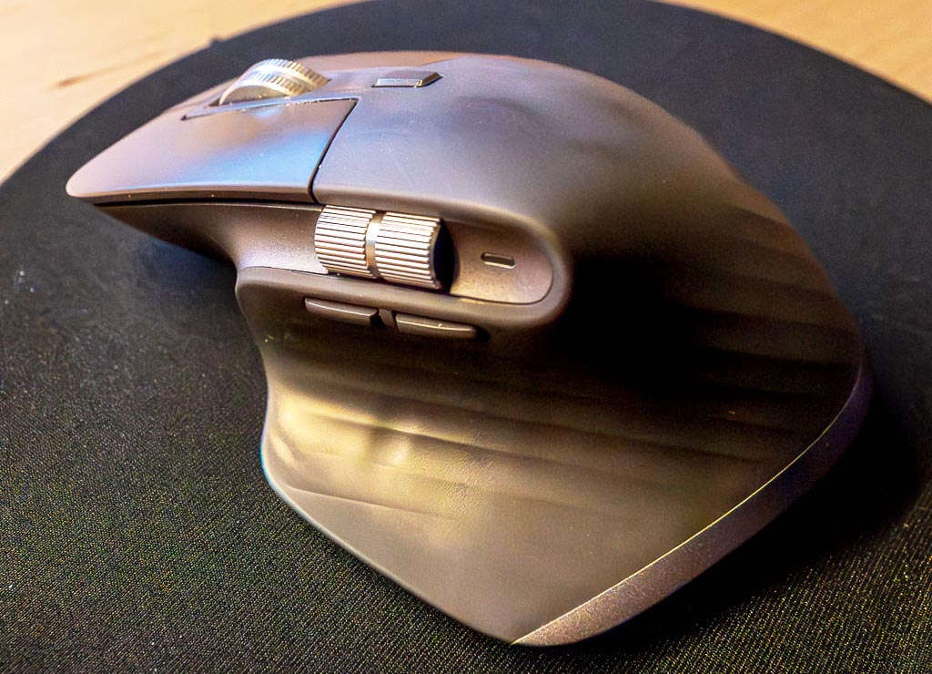 Tag der Computermaus. Kuriose Feiertage – 17. November 2025 (c) Sven Giese - Bild 2 Ergonomische Computermaus seitlich auf schwarzem Mauspad, mit Daumenrad und Seitentasten.