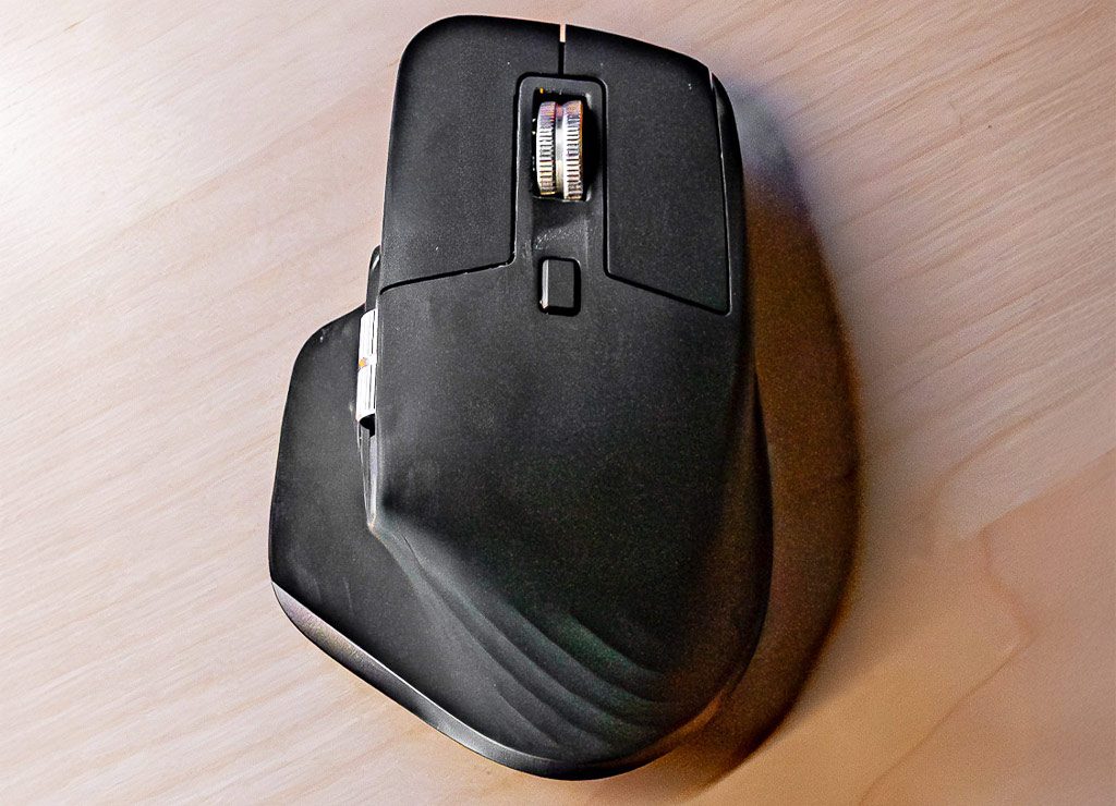 Tag der Computermaus. Kuriose Feiertage – 17. November 2025 (c) Sven Giese - Bild 3 Schwarze ergonomische Maus in Draufsicht auf Holz, zentrales Scrollrad und breite Auflage.