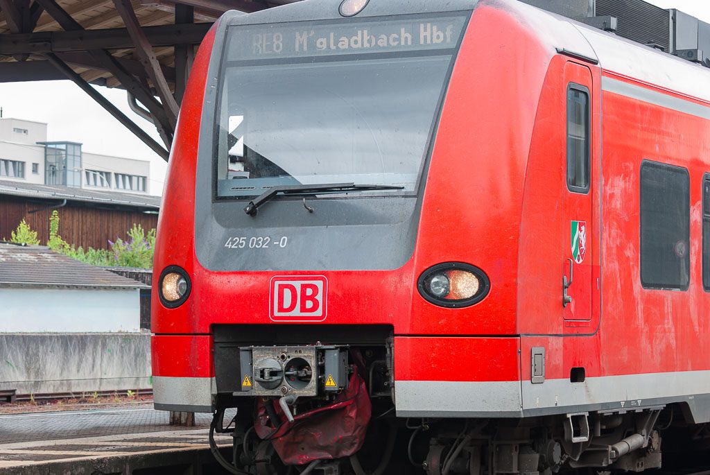 oter Regionalzug der Deutschen Bahn steht am Bahnhof, Zielanzeige Mönchengladbach Hbf sichtbar.